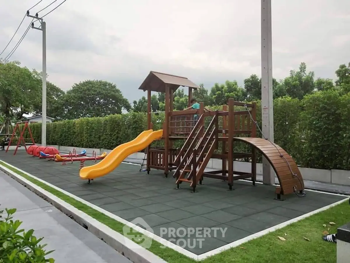 Charming outdoor playground in residential community with slide and climbing structure.