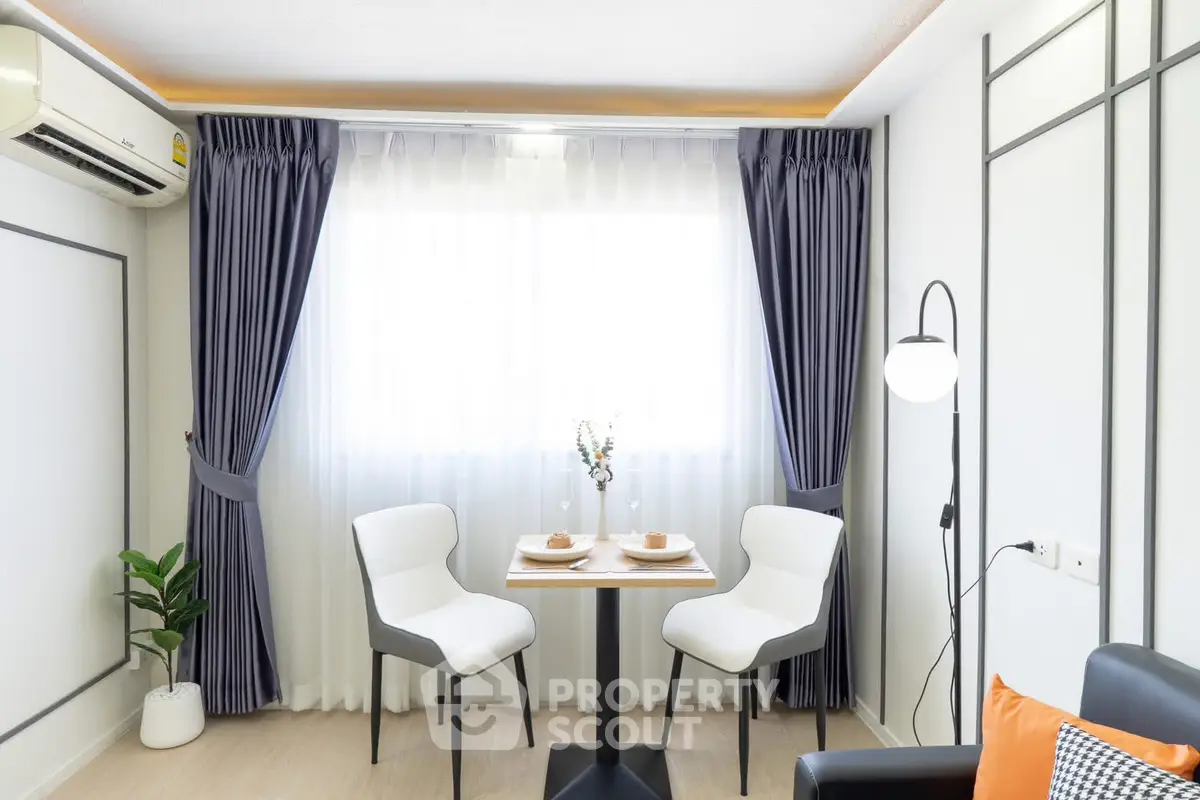 Chic modern dining area with elegant curtains and cozy seating in a bright apartment.