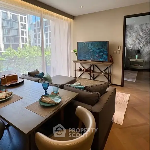 Modern living room with stylish decor and large windows offering a city view, adjacent to a cozy bedroom.