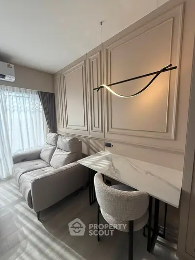 Modern living room with elegant lighting and cozy seating area, featuring a stylish marble table.