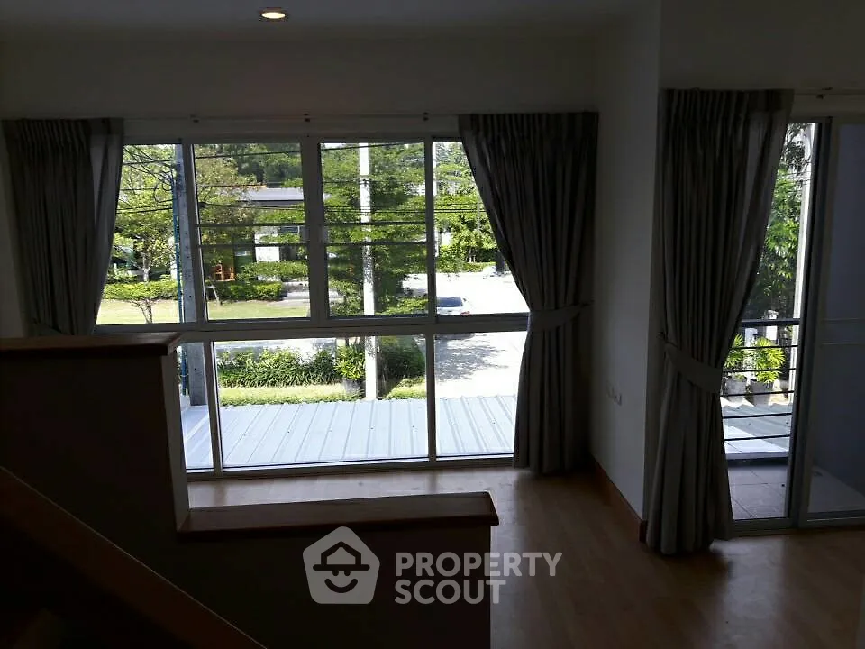 Spacious room with large windows offering a serene garden view, perfect for natural light lovers.