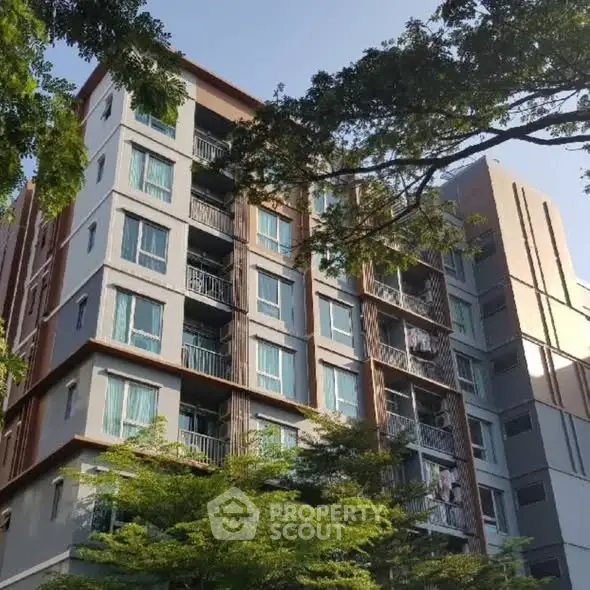 Modern apartment building with lush greenery and clear blue sky