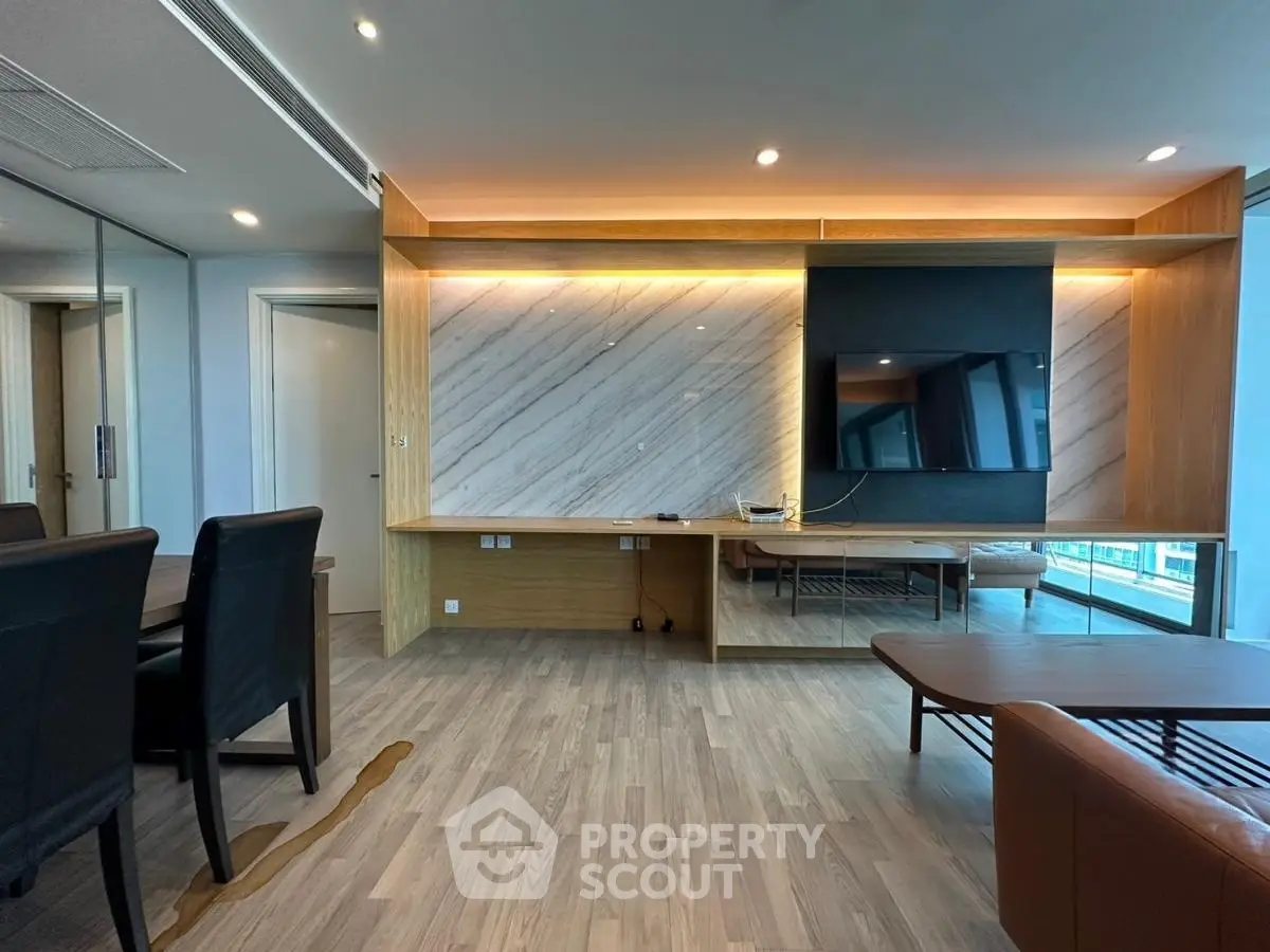 Modern living room with sleek wooden flooring and stylish wall paneling