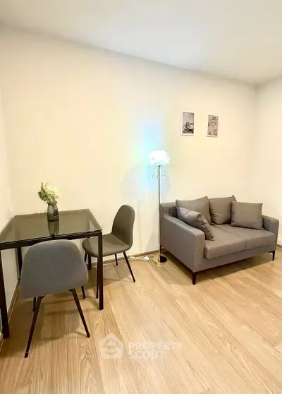 Modern living room with cozy gray sofa and dining table, perfect for urban living.