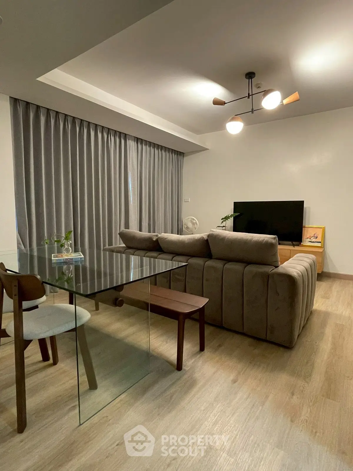 Modern living room with stylish sofa and glass dining table, perfect for contemporary living.
