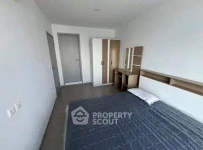 Modern minimalist bedroom with sleek furniture and ample natural light.