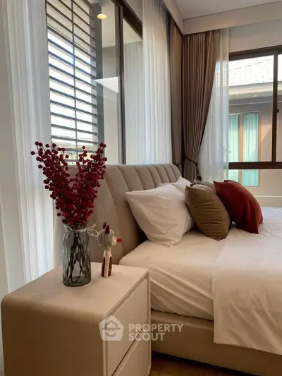 Luxurious bedroom with elegant decor and large windows offering natural light.