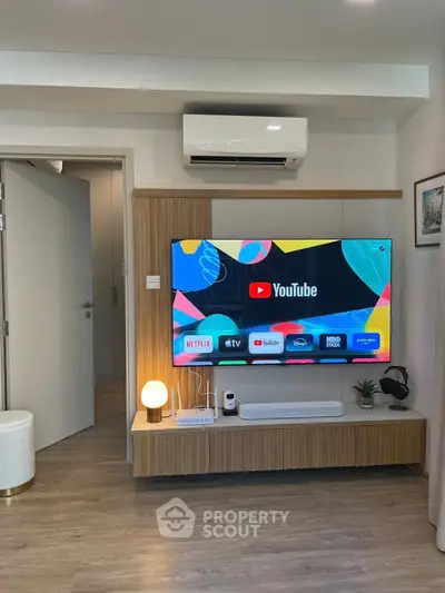 Modern living room with smart TV and stylish wooden entertainment unit.