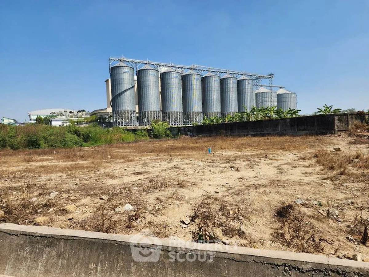 Expansive industrial land with silos, ideal for development opportunities.