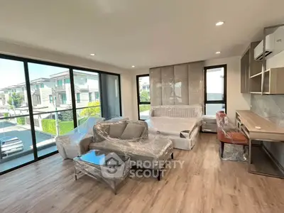Spacious modern living room with large windows and stylish furniture in a contemporary home.