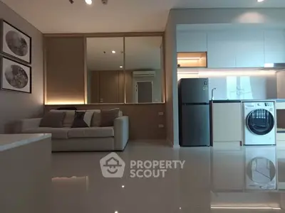 Modern living room with sleek kitchen, featuring a cozy sofa and built-in appliances for stylish urban living.
