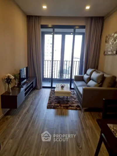 Modern living room with stylish decor and balcony view, perfect for urban living.