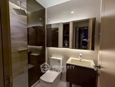 Modern bathroom with sleek design, featuring a glass shower enclosure and stylish vanity.