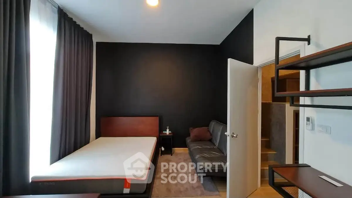 Modern bedroom with sleek black accent wall and cozy furnishings