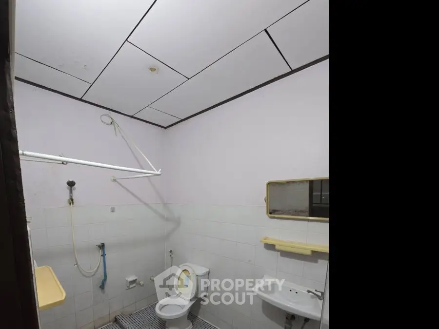 Basic bathroom with shower, toilet, and sink in a minimalist design.