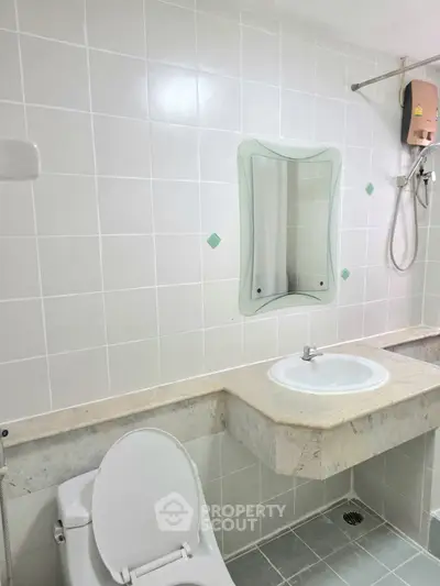 Modern bathroom with sleek design featuring a marble countertop and wall-mounted shower.