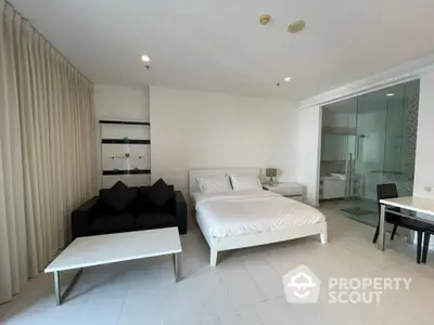 Modern studio apartment with sleek design, featuring a cozy bed, stylish sofa, and elegant glass-enclosed bathroom.