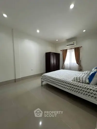 Spacious bedroom with modern decor and ample natural light