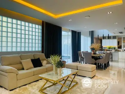 Luxurious open-plan living space with elegant sofa set, modern dining area, and ambient lighting, perfect for sophisticated living.