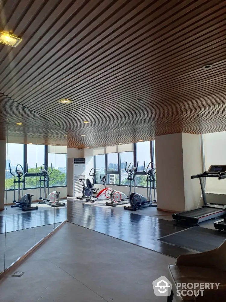 Modern gym with city view and exercise equipment in luxury building