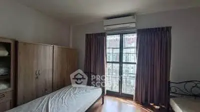 Cozy bedroom with twin beds and large window for natural light.