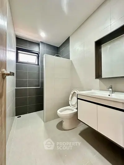 Modern bathroom with sleek design and neutral tones, featuring a spacious shower area.
