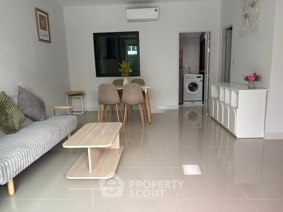 Modern living room with sleek furniture and washing machine in open layout