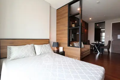 Modern bedroom with stylish wooden partition and cozy seating area