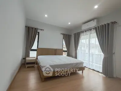Spacious bedroom with natural light and modern furnishings in a stylish apartment.