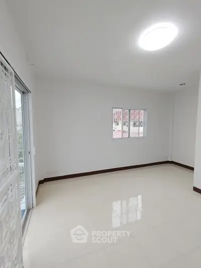 Spacious and bright empty room with large windows and tiled floor