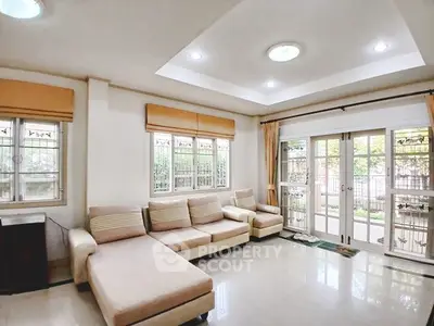 Spacious living room with large windows and cozy seating area