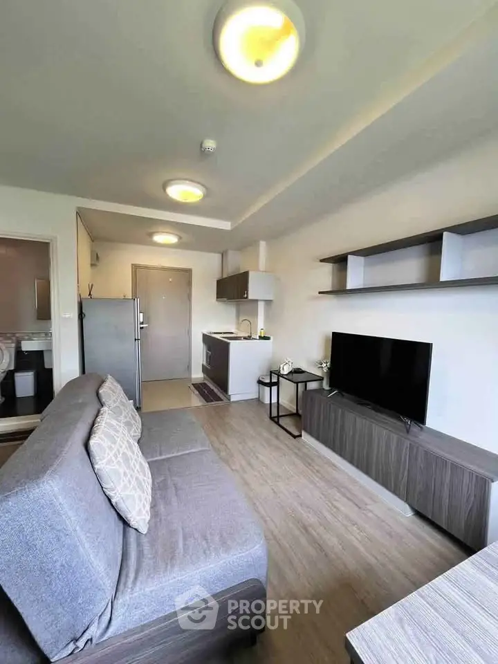 Modern living room with sleek furniture and open kitchen layout in a stylish apartment.