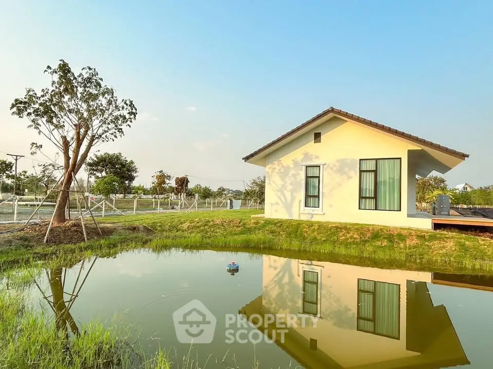 Charming single-story house with serene pond and lush greenery