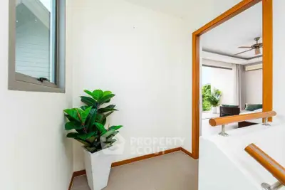 Bright hallway leading to a cozy living room with modern decor and natural light.
