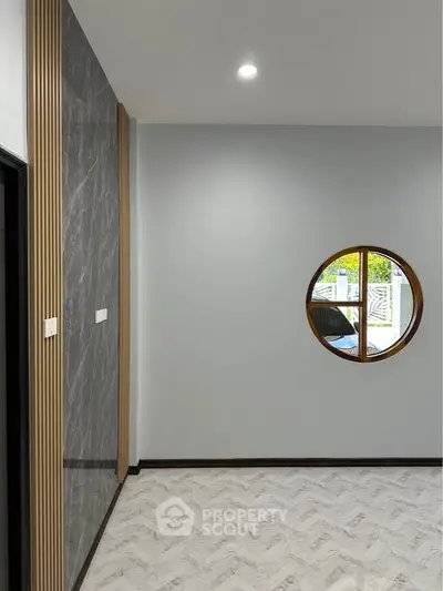 Modern interior with circular window and stylish wall design, perfect for contemporary living spaces.