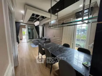 Luxurious modern living room with elegant dining area and large windows offering natural light.