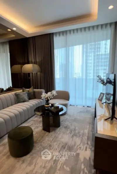 Luxurious modern living room with elegant decor and large windows offering natural light.