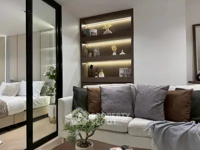 Modern living room with cozy sofa and elegant decor adjacent to a stylish bedroom.