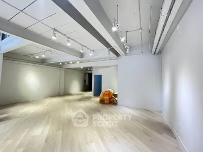 Spacious open-plan interior with modern lighting and wooden flooring, ideal for versatile use.