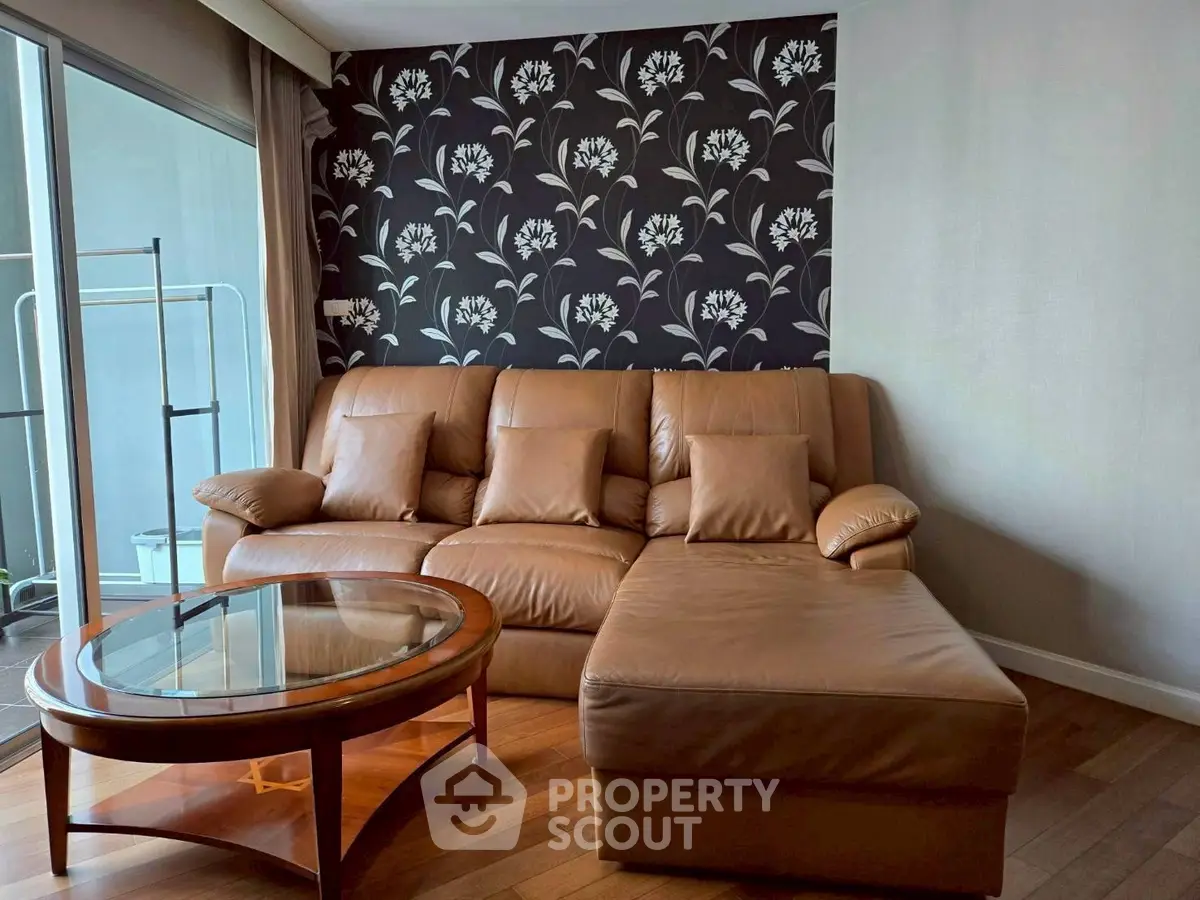 Stylish living room with leather sofa and floral accent wall