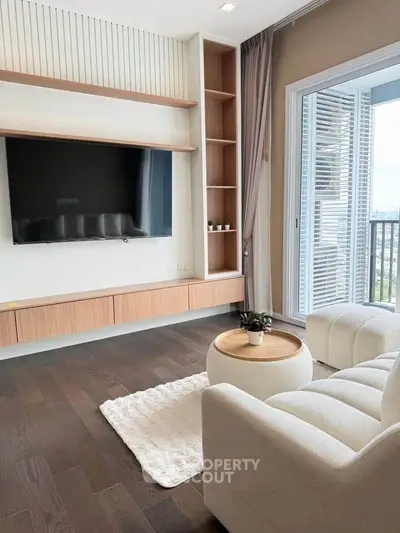 Modern living room with sleek TV setup and cozy seating area, featuring a large window with a stunning view.