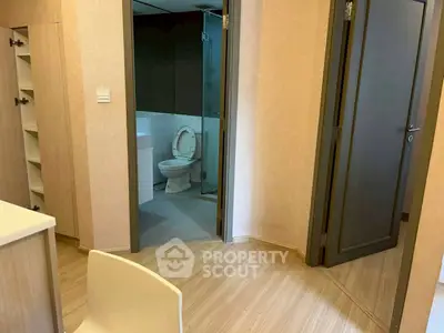 Modern apartment interior with bathroom and wooden flooring, showcasing sleek design and functionality.