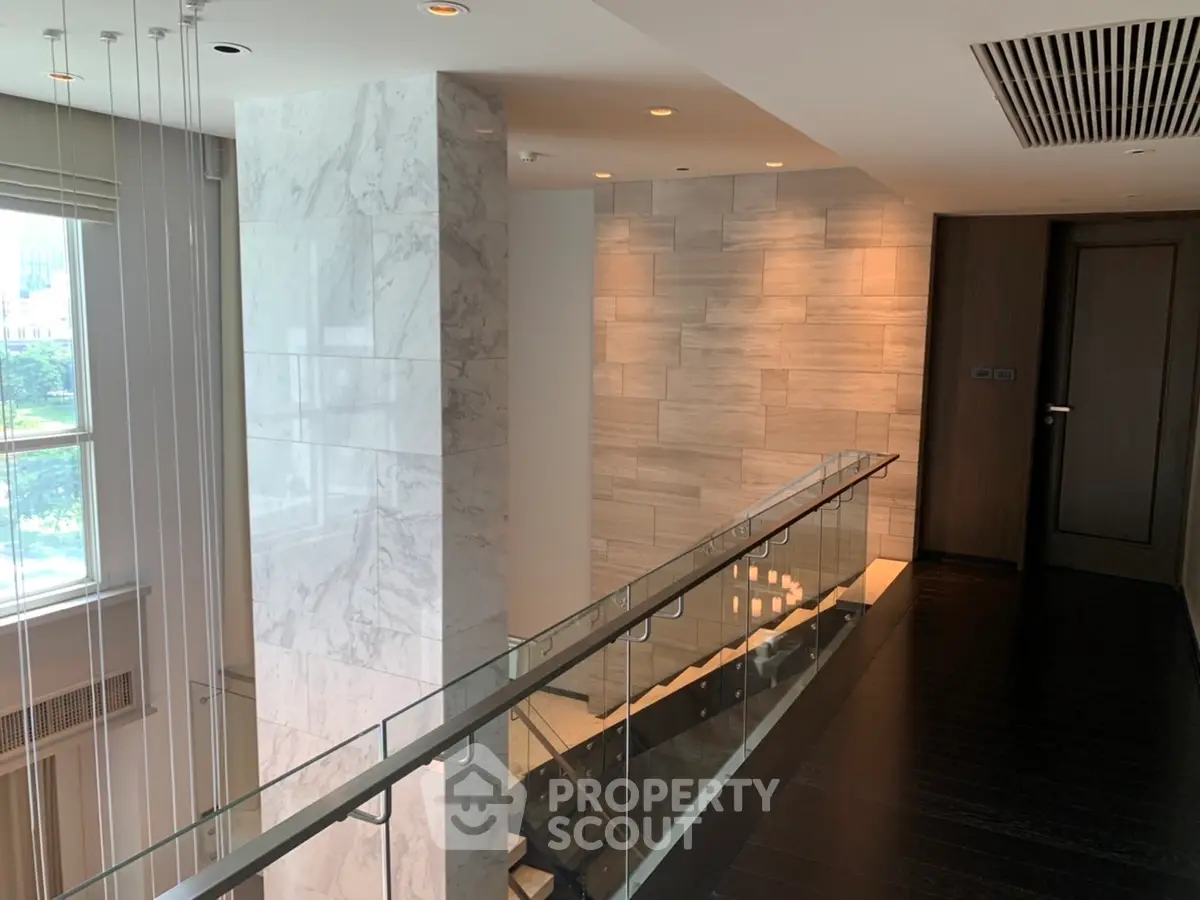 Luxurious modern interior with marble accents and glass railing in upscale building