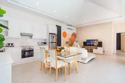 Spacious modern living room with open kitchen, dining area, and stylish decor.