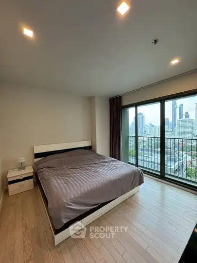 Modern bedroom with city view and large windows in high-rise apartment