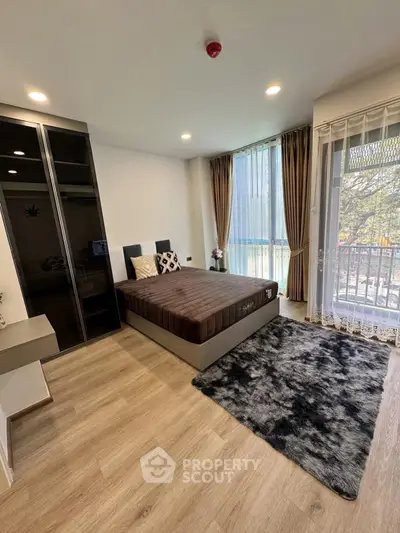 Modern bedroom with large windows and stylish decor in a cozy apartment.
