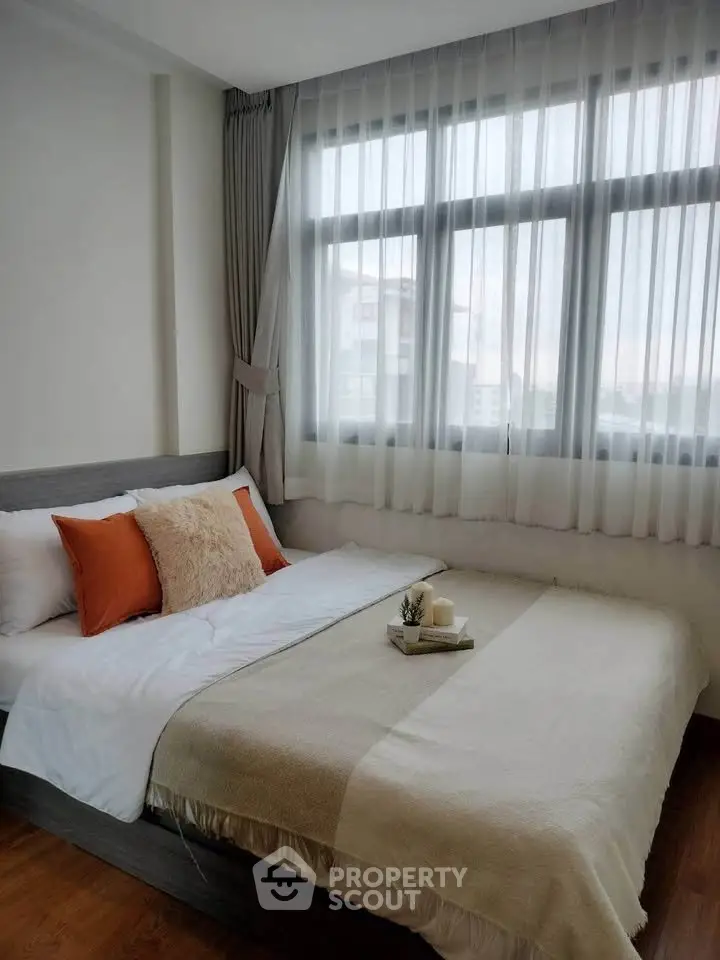 Cozy bedroom with large window and stylish decor in modern apartment