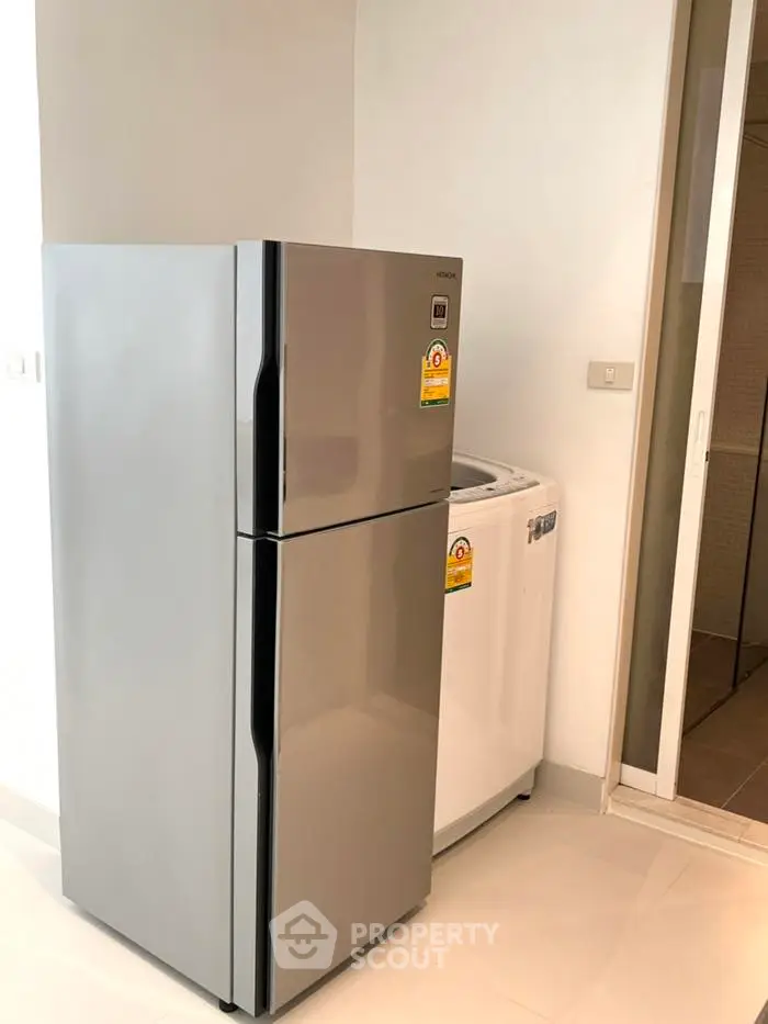 Modern kitchen with sleek fridge and washing machine in bright interior
