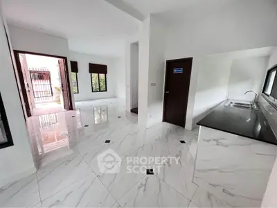 Spacious open-plan living area with modern kitchen and elegant tile flooring