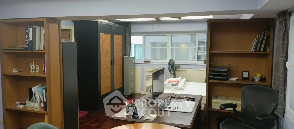 Spacious home office with wooden shelves and modern desk setup